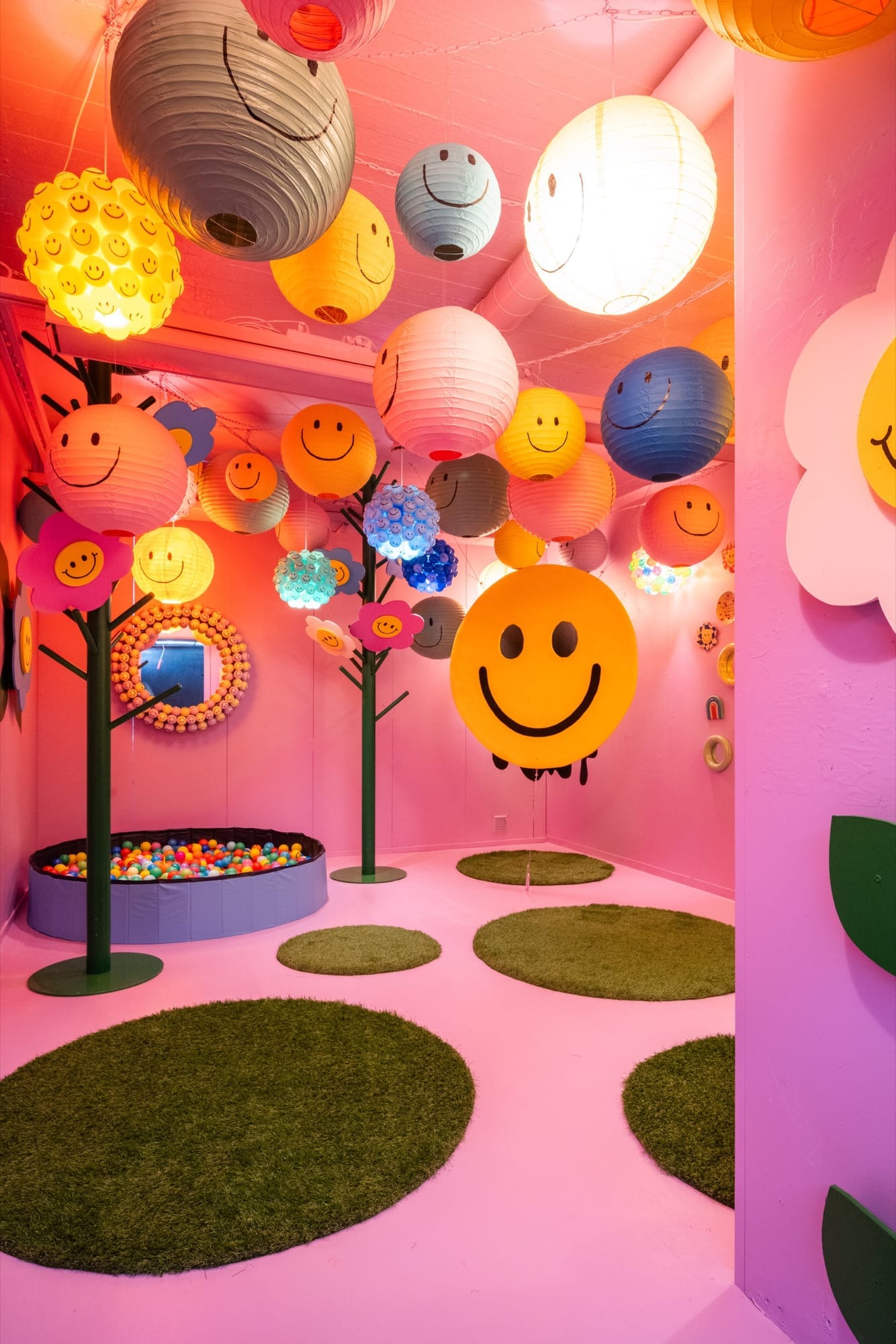 A bright room filled with smiling-face lanterns and flowers